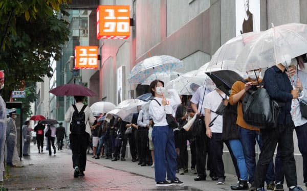 ユニクロのグローバル旗艦店「UNIQLO TOKYO」の開業を待つ人たち(19日午前、東京都中央区)