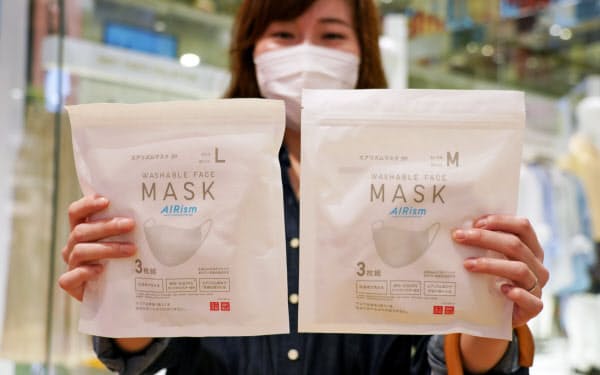 発売されたユニクロの「エアリズムマスク」を手にする女性(19日午前、東京都中央区のユニクロ銀座店)