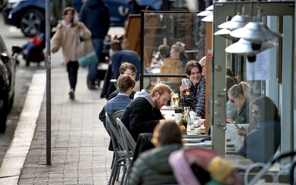 都市封鎖されていないスウェーデンの首都ストックホルムのレストランで人々は食事を楽しむ=ロイター