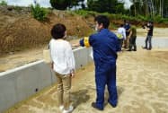 宅地の造成工事が終わり、熊本県職員と土地の広さなどを確認する地権者家族ら(25日午後、熊本県益城町)=共同 宅地の造成工事が終わり、熊本県職員と土地の広さなどを確認する地権者家族ら(25日午後、熊本県益城町)=共同