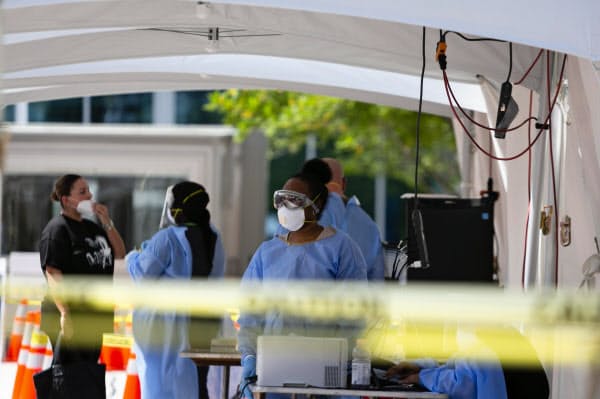 新型コロナウイルス検査場の医療従事者(26日、米フロリダ州)=ゲッティ共同