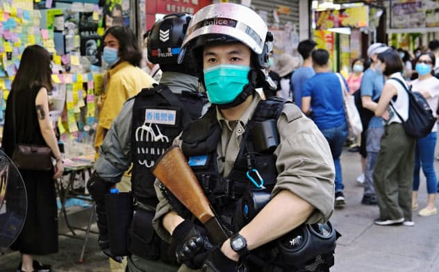 香港の繁華街では警官がデモの取り締まりにあたる=ロイター 香港の繁華街では警官がデモの取り締まりにあたる=ロイター