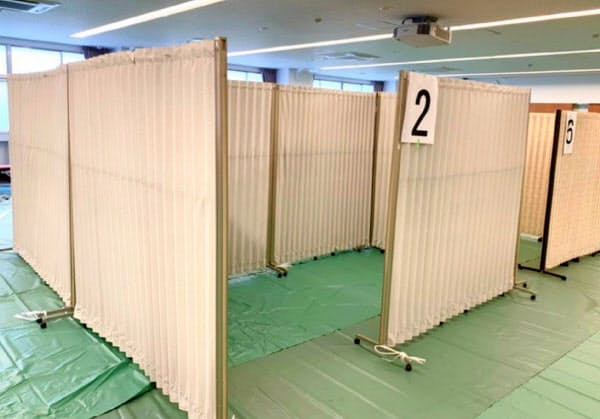 感染の疑いがある人らが過ごす「一時避難所」には、一人ひとりが距離をとれるよう間仕切りを設置(福岡市)