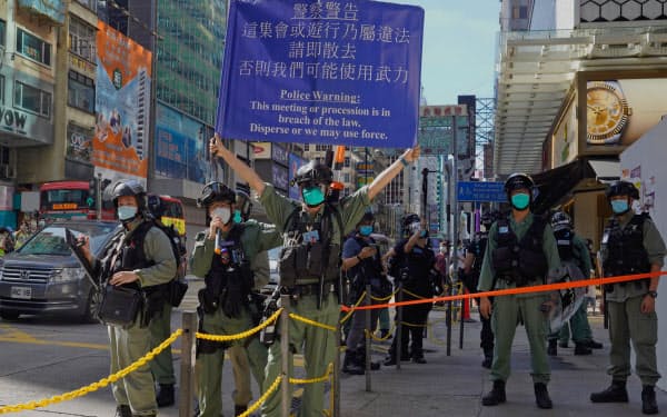 28日、香港の街で警戒に当たる警察官=AP