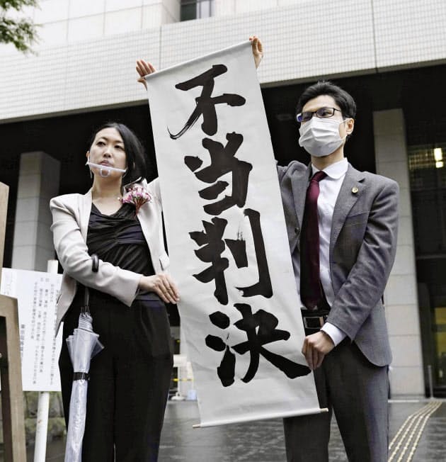 東京地裁が原告の請求を棄却し、掲げられた「不当判決」の垂れ幕（30日、東京地裁前）