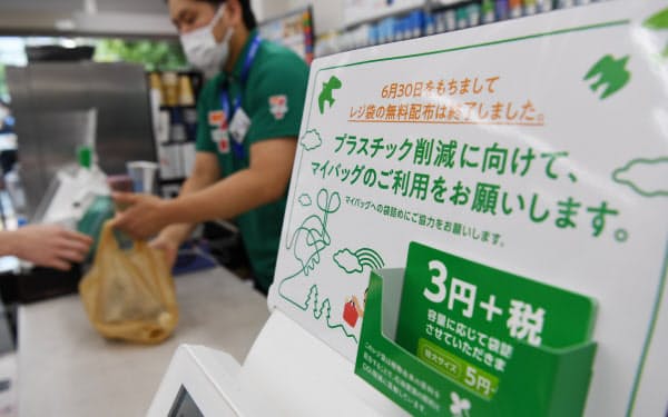 レジ袋の有料化を知らせる案内が掲示されたセブンイレブンの店舗(1日午前、東京都港区)