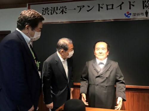 アンドロイドを間近で見るドトールコーヒーの鳥羽名誉会長(中央)と深谷市の小島市長(左)