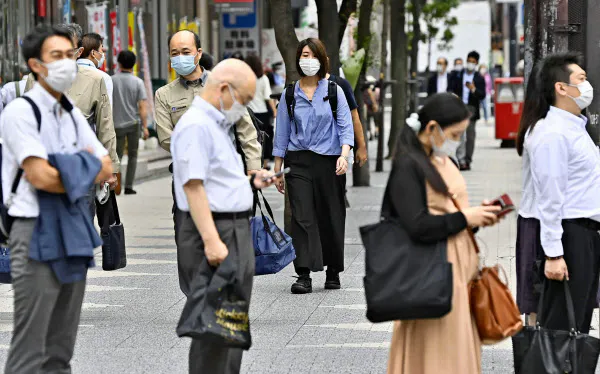 東京・新橋をマスク姿で歩く人たち(3日午後)=共同