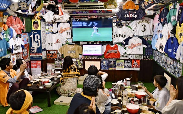 プロ野球公式戦が開幕した6月19日、東京・神田の居酒屋でテレビ観戦するファン。解説と実況がかみ合えばファンもより楽しめるはずだ=共同