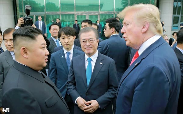 韓国の文在寅大統領(中)は「米朝首脳会談開催に全力を尽くす」と話す(写真は19年6月の首脳会談)=朝鮮中央通信・共同