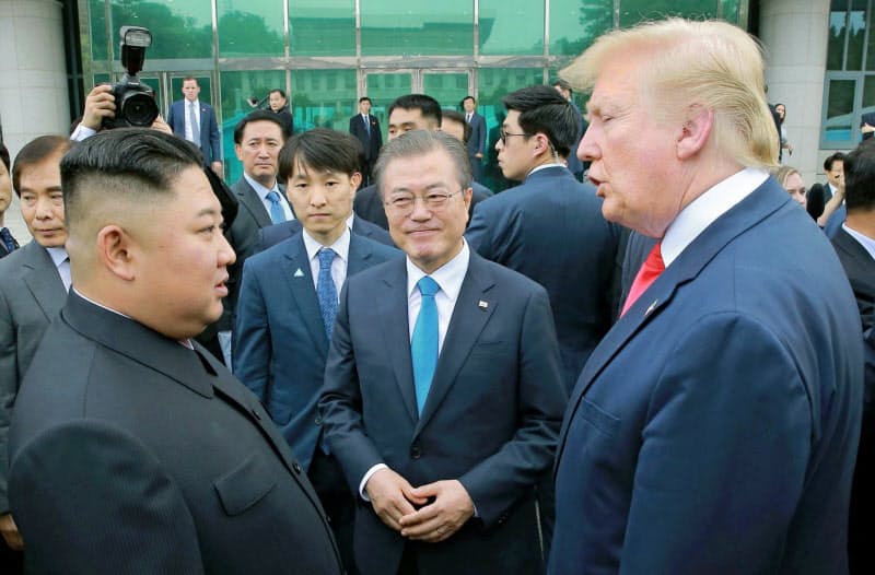 韓国の文在寅大統領(中)は「米朝首脳会談開催に全力を尽くす」と話す（写真は19年６月の首脳会談）＝朝鮮中央通信・共同