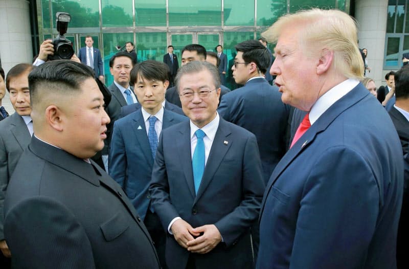 韓国の文在寅大統領(中)は「米朝首脳会談開催に全力を尽くす」と話す(写真は19年6月の首脳会談)=朝鮮中央通信・共同 韓国の文在寅大統領(中)は「米朝首脳会談開催に全力を尽くす」と話す(写真は19年6月の首脳会談)=朝鮮中央通信・共同