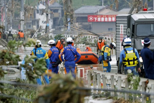 水に漬かった熊本県球磨村で救助活動をする自衛隊員や警察関係者ら(5日午前8時29分)=共同