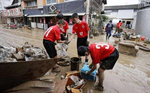 土砂が流入した熊本県人吉市で片付けをする地元少年サッカーチームの中学生(5日午前9時33分)=共同