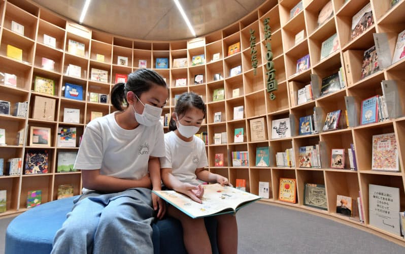 「こども本の森 中之島」で本を手にする女の子(5日、大阪市)=共同 「こども本の森 中之島」で本を手にする女の子(5日、大阪市)=共同