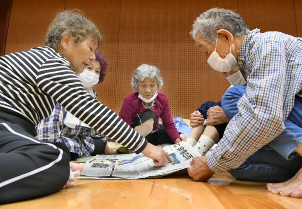 浸水で孤立した地区から救助され体育館に避難した人たち(6日午前、熊本県八代市)