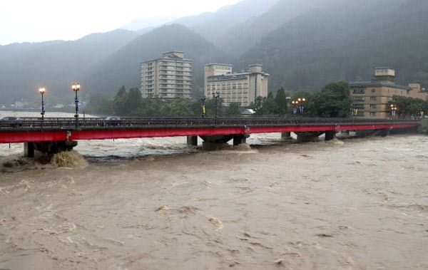 大雨により増水した飛騨川(8日午前、岐阜県下呂市)=共同