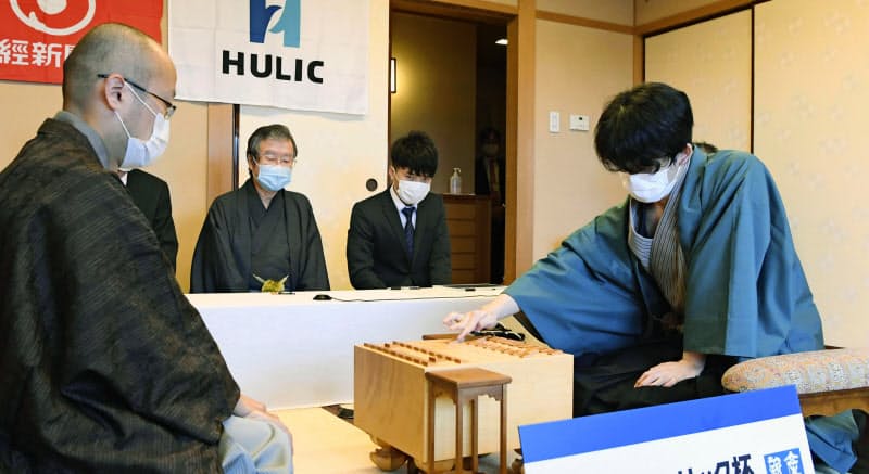 第91期棋聖戦5番勝負の第3局で初手を指す藤井聡太七段(右)。左は渡辺明棋聖(9日、東京都千代田区)=代表撮影・共同 第91期棋聖戦5番勝負の第3局で初手を指す藤井聡太七段(右)。左は渡辺明棋聖(9日、東京都千代田区)=代表撮影・共同