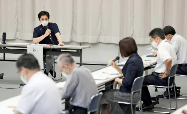 大阪府の新型コロナウイルス対策本部会議で発言する吉村洋文知事(左奥、12日午後、大阪市)=共同