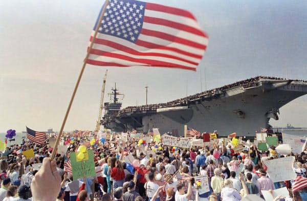 1991年3月、湾岸戦争で勝利し寄航した米空母を出迎える人たち。一方で国内景気は低迷し、ブッシュ氏は再選できなかった(AP)