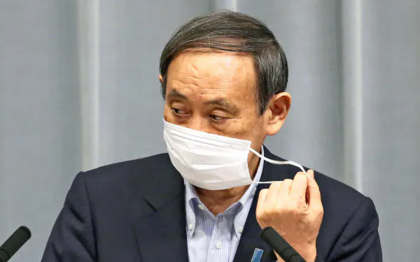 マスクを外し、記者会見に臨む菅官房長官(30日午前、首相官邸)=共同