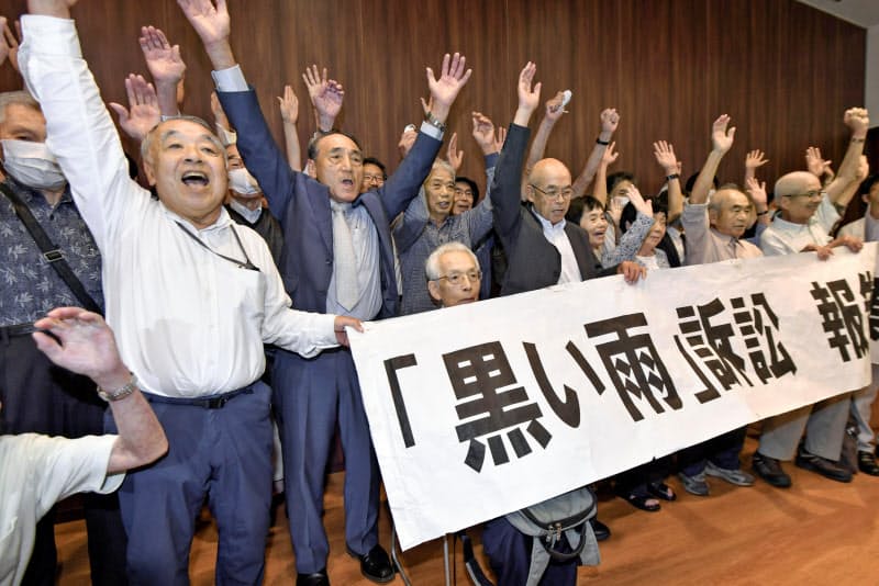 「黒い雨」訴訟で全面勝訴し、報告集会で万歳する(左から)訴訟を支援する会の高東征二事務局長、高野正明原告団長ら=29日午後、広島市 「黒い雨」訴訟で全面勝訴し、報告集会で万歳する(左から)訴訟を支援する会の高東征二事務局長、高野正明原告団長ら=29日午後、広島市