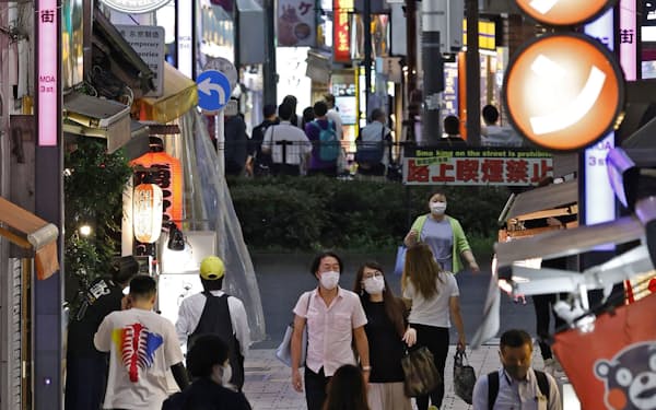 東京・新宿の繁華街をマスク姿で歩く人たち（30日夕）
