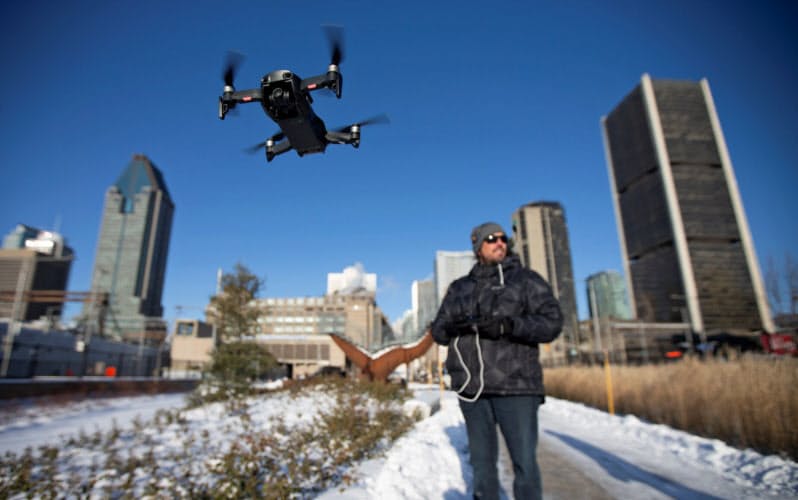 カナダ・モントリオールでDJI製のドローンをデモ飛行する男性。同社のドローンはノートルダム寺院の消防活動に活躍した=ロイター カナダ・モントリオールでDJI製のドローンをデモ飛行する男性。同社のドローンはノートルダム寺院の消防活動に活躍した=ロイター