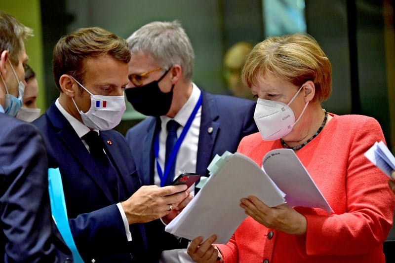 EU首脳会談で懇談するメルケル独首相(右)とマクロン仏大統領=ロイター EU首脳会談で懇談するメルケル独首相(右)とマクロン仏大統領=ロイター