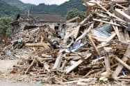 球磨川沿いの住宅地に残るがれきの山(1日、熊本県球磨村)=共同 球磨川沿いの住宅地に残るがれきの山(1日、熊本県球磨村)=共同