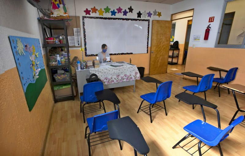 生徒のいない教室で1人で作業する教師(7月、メキシコシティ)=AP 生徒のいない教室で1人で作業する教師(7月、メキシコシティ)=AP