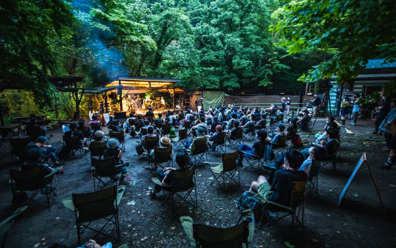 木々に囲まれたキャンプ場で開かれた「＃ライブフォレストフェス」。スタンディングが基本の野外フェスだが、観客には着席か、決められたエリアで立つことだけが許された（７月31日、東京都あきる野市）