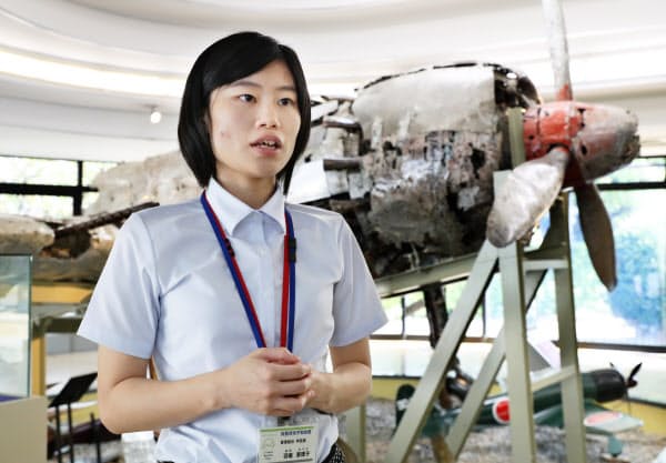 零式艦上戦闘機の前で話す知覧特攻平和会館学芸員の羽場恵理子さん(鹿児島県南九州市)