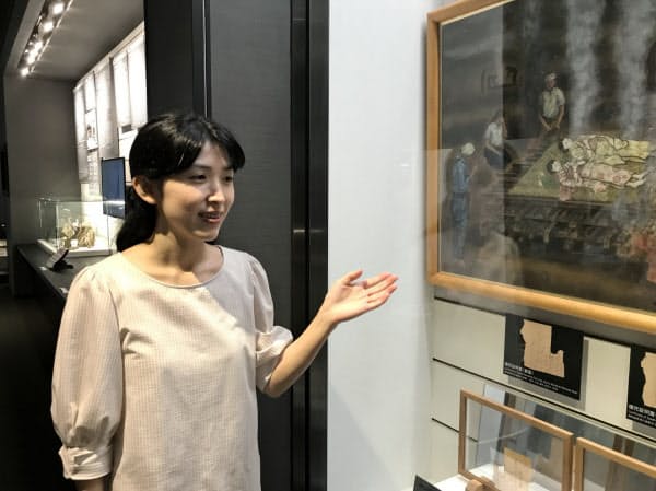 長崎原爆資料館の展示物を解説する学芸員の弦本美菜子さん(長崎市)