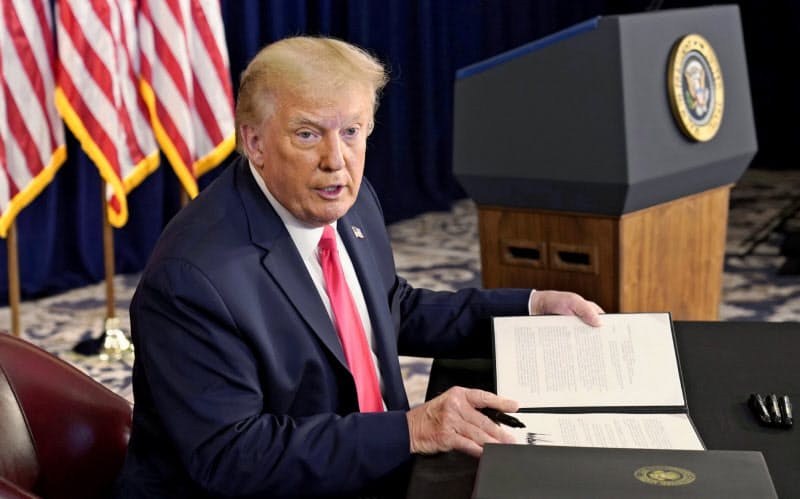 トランプ氏は失業給付を上乗せする大統領令に署名した(8日、米ニュージャージー州)=ロイター トランプ氏は失業給付を上乗せする大統領令に署名した(8日、米ニュージャージー州)=ロイター