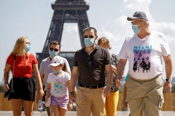 マスクをしてエッフェル塔の近くを歩く人々(8月9日、パリ)=ロイター