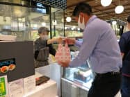 東急百貨店の社員が料理を受け取り、ドライバーに手渡す(11日、東京都渋谷区) 東急百貨店の社員が料理を受け取り、ドライバーに手渡す(11日、東京都渋谷区)