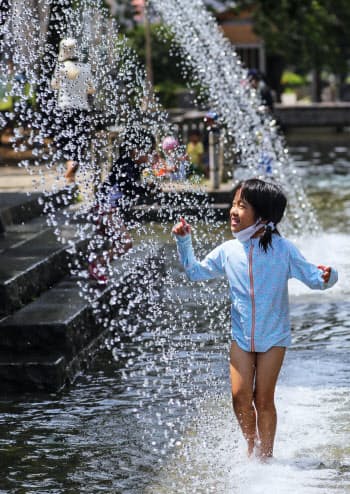 厳しい暑さの中、水遊びを楽しむ子も(19日午前、東京都葛飾区)