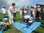 子どもらに説明するオプティムアグリ・みちのくの社員(青森県黒石市) 子どもらに説明するオプティムアグリ・みちのくの社員(青森県黒石市)