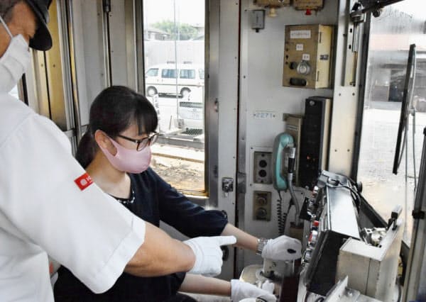 和歌山電鉄が車両基地で開いた電車を運転する体験会に参加した瓜生田彩月さん(22日午前、和歌山市)=共同