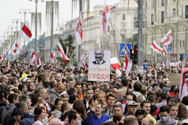 「辞めろ」と書いたプラカードを手にした市民らが中心部を行進した(23日、ミンスク)=AP