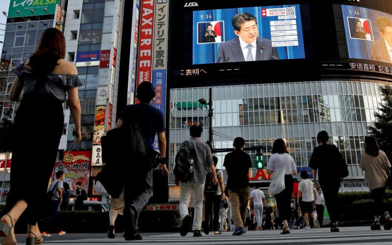 8月28日、安倍首相の辞任会見を映す街頭スクリーンを見る東京の人々=ロイター 8月28日、安倍首相の辞任会見を映す街頭スクリーンを見る東京の人々=ロイター