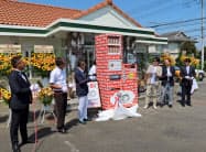 自販機などの完成を祝いジンズホールディングスの田中仁社長(右から3人目)らが駆けつけた(8月29日、前橋市) 自販機などの完成を祝いジンズホールディングスの田中仁社長(右から3人目)らが駆けつけた(8月29日、前橋市)