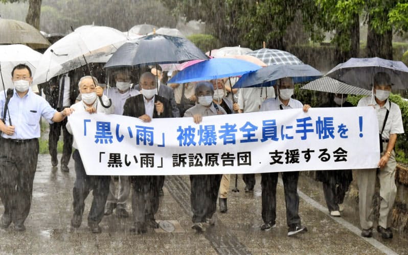 「黒い雨」訴訟の判決で広島地裁に向かう原告団(7月29日午後)=共同 「黒い雨」訴訟の判決で広島地裁に向かう原告団(7月29日午後)=共同