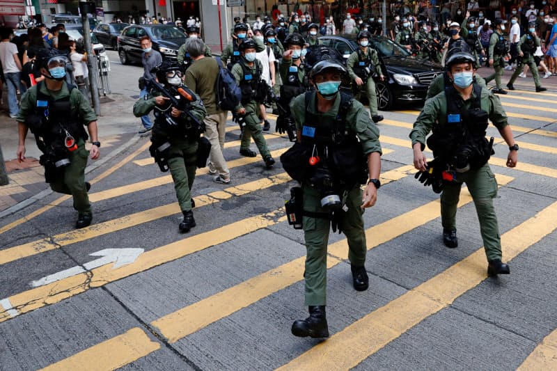 繁華街でデモ参加者を取り締まる警察官(6日、香港)=ロイター 繁華街でデモ参加者を取り締まる警察官(6日、香港)=ロイター