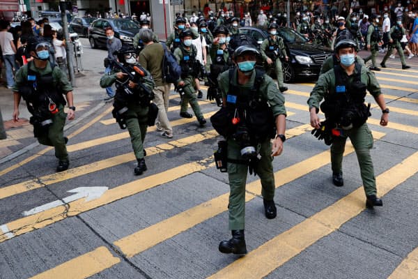 繁華街でデモ参加者を取り締まる警察官（6日、香港）=ロイター