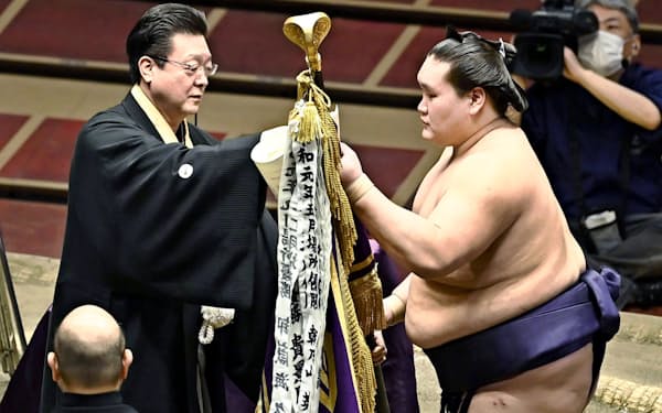 7月場所で師匠の伊勢ケ浜親方（左）から優勝旗を受け取る照ノ富士（日本相撲協会提供）=共同
