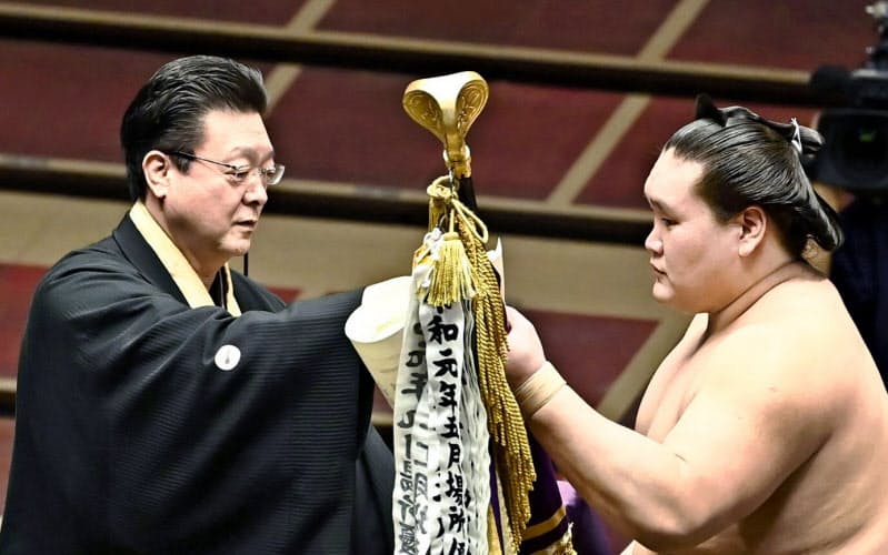 7月場所で師匠の伊勢ケ浜親方(左)から優勝旗を受け取る照ノ富士(日本相撲協会提供)=共同 7月場所で師匠の伊勢ケ浜親方(左)から優勝旗を受け取る照ノ富士(日本相撲協会提供)=共同