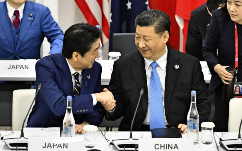 2019年6月、G20大阪サミットの会合で、中国の習近平国家主席(右)と笑顔で握手を交わす安倍首相=大阪市 2019年6月、G20大阪サミットの会合で、中国の習近平国家主席(右)と笑顔で握手を交わす安倍首相=大阪市