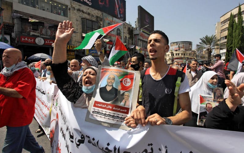 15日、ヨルダン川西岸で、バーレーンやアラブ首長国連邦とイスラエルの国交正常化に抗議するパレスチナの人々=ゲッティ共同 15日、ヨルダン川西岸で、バーレーンやアラブ首長国連邦とイスラエルの国交正常化に抗議するパレスチナの人々=ゲッティ共同